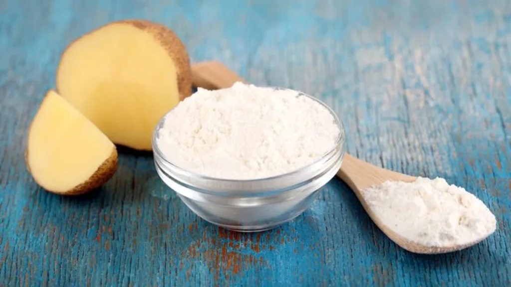 a bowl of potato starch next to a potato